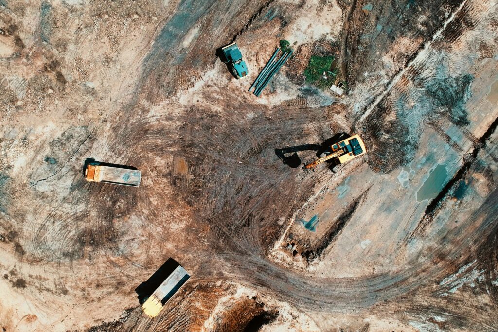 토지수용보상금 70억 원 항소심 전부승소 사례 High-angle aerial view of construction site with earthmoving equipment and trucks.